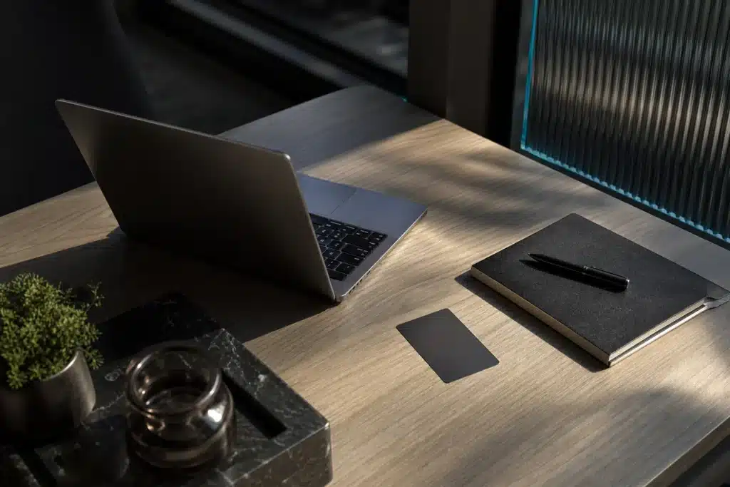 Laptop, face-down payment card and notebook arranged for an illustrative purchase review