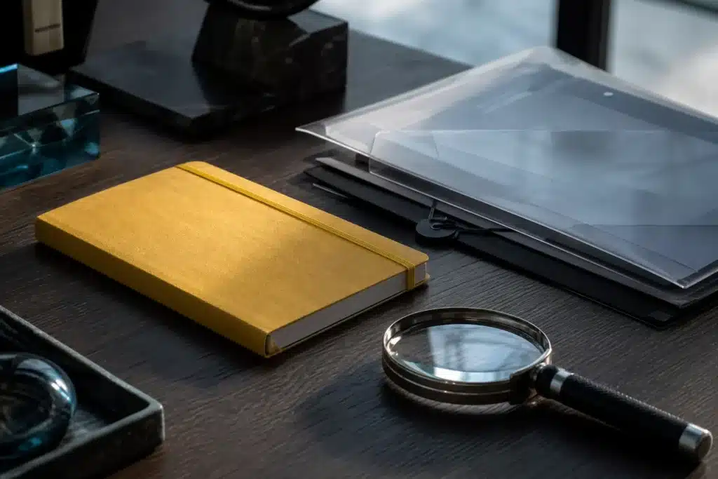 Research notebook and magnifying glass on a desk used to examine cryptocurrency information