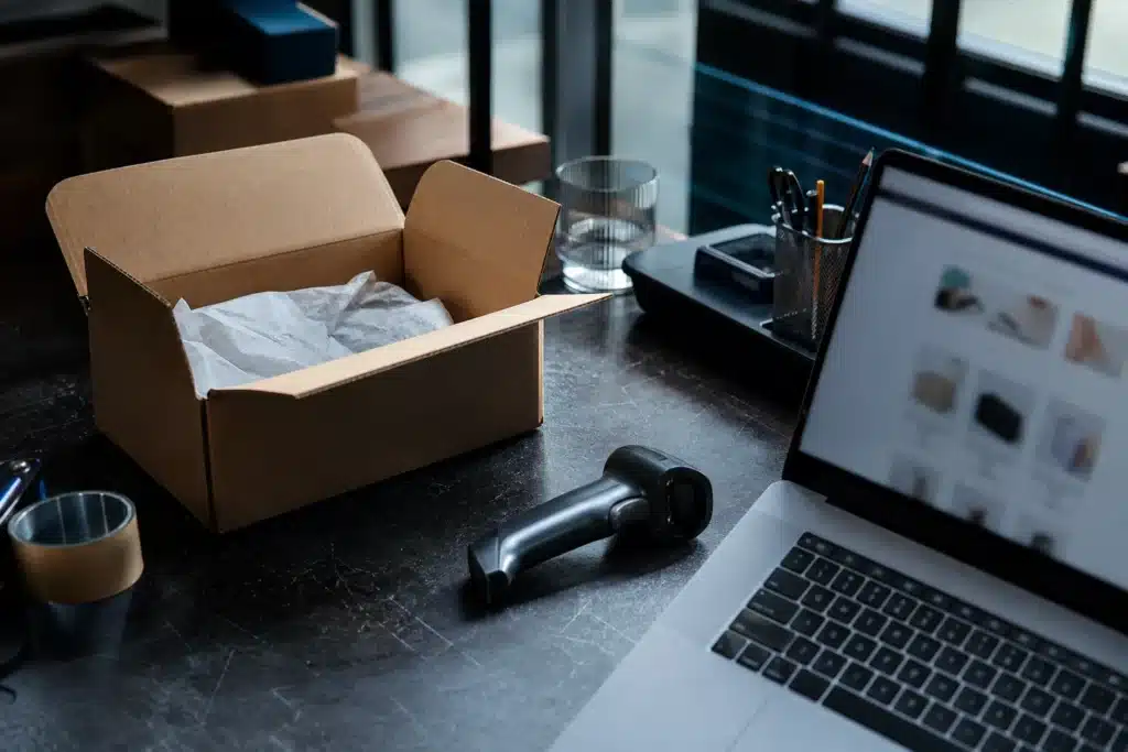 Offener Versandkarton und Checkout-Arbeitsplatz in einem kleinen Onlinehandelsbetrieb