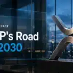 Brushed-metal XRP sculpture in a glass atrium illustrating XRP price prediction 2026-2030